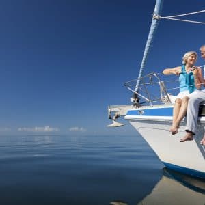 Happy Senior Couple On The Bow Of A Sail Boat