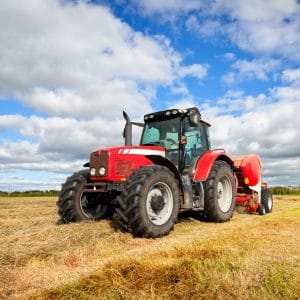 Tractor Collecting Haystack In The Field